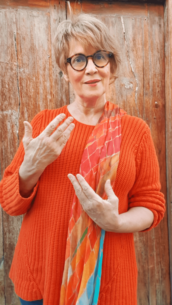 Susanne mit orangen Pullover beim Austausch mit anderen